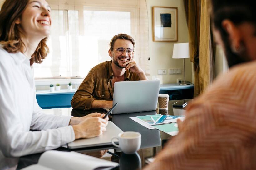 Amis heureux qui travaillent autour d’une table